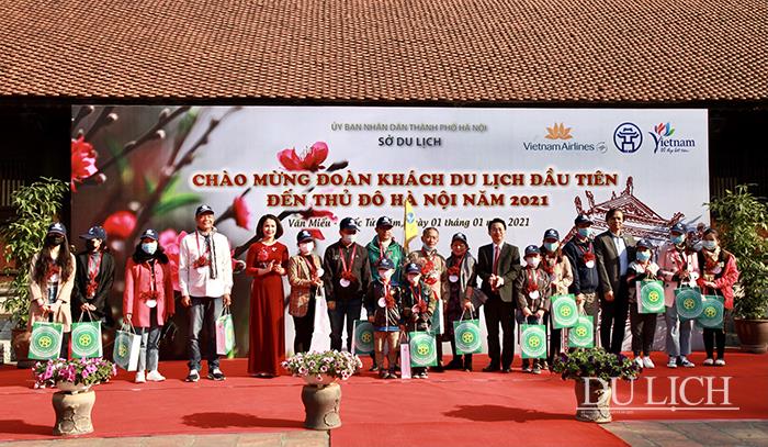 Tặng quà cho các thành viên đoàn du khách đầu tiên đến Hà Nội đầu năm 2021